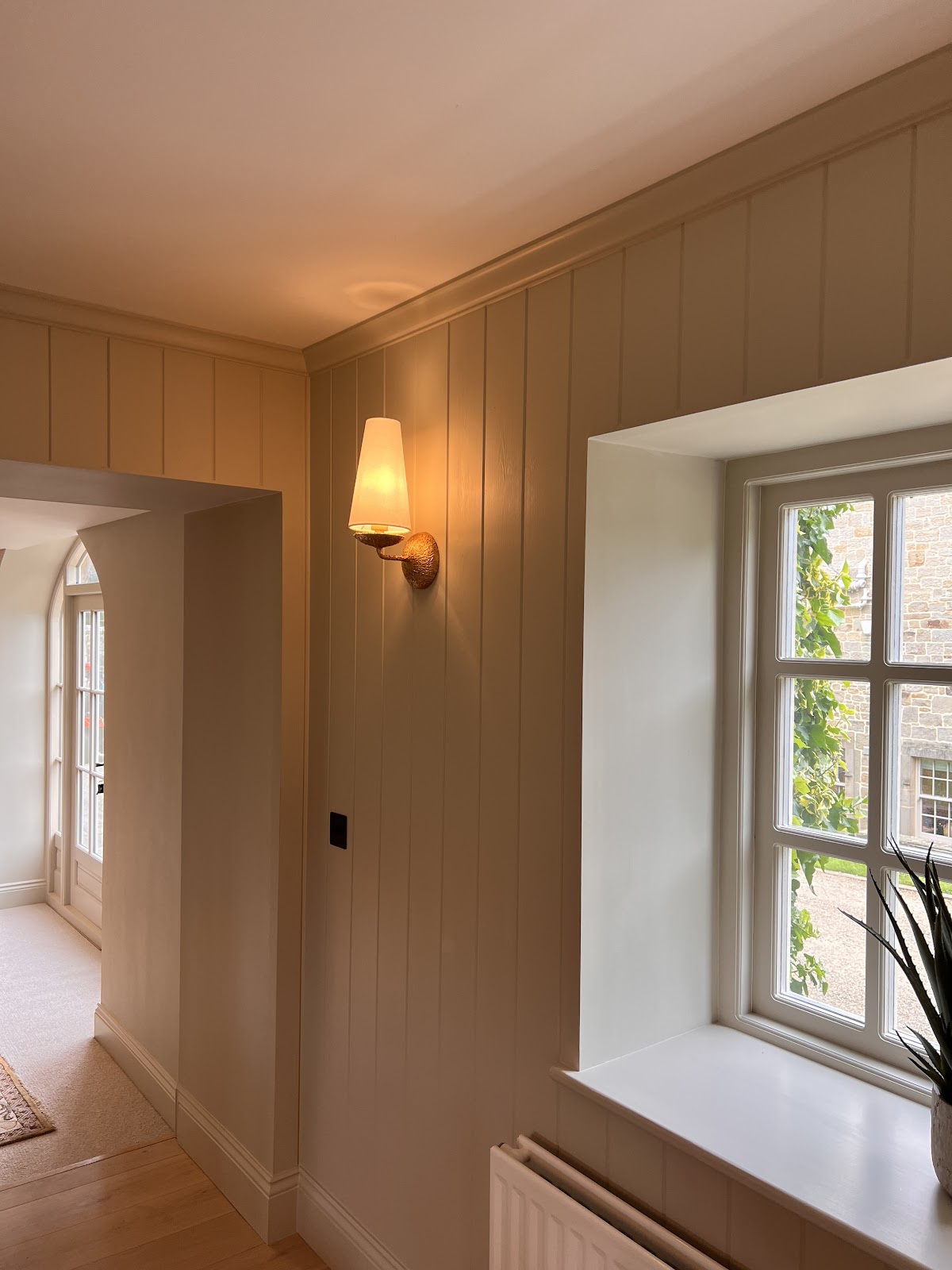 Panelled hallway with a bronze feature wall light